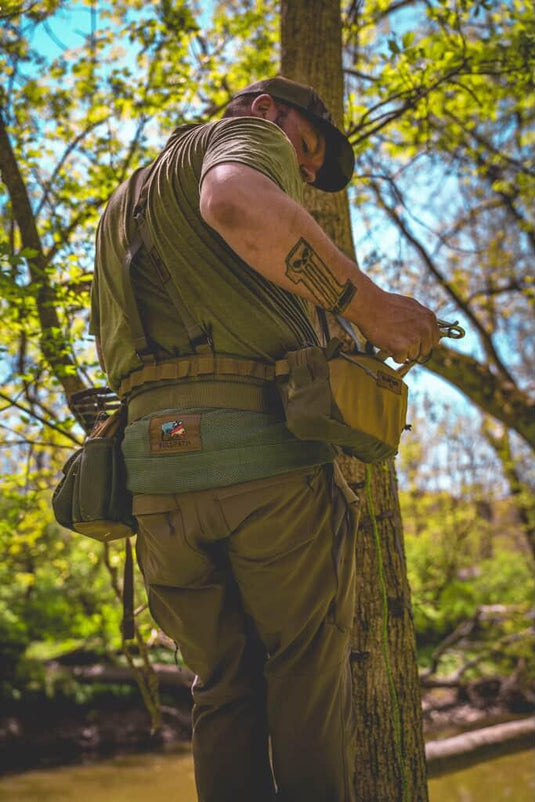a man wearing a hunting saddle from Bullpath in a tree