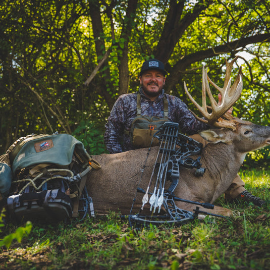 a man holding a buck with an El Toro hunting saddle