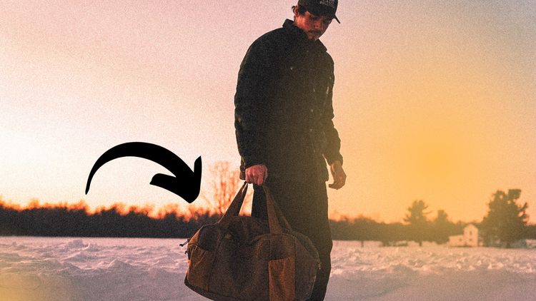 drew eyink holding a bullpath duffel in a road