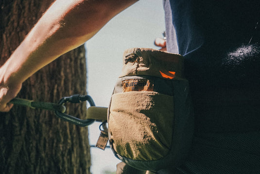 BullPath S.A.M. X small dump pouch clipped to a saddle hunting harness on a tree, mobile hunting gear storage in the field.